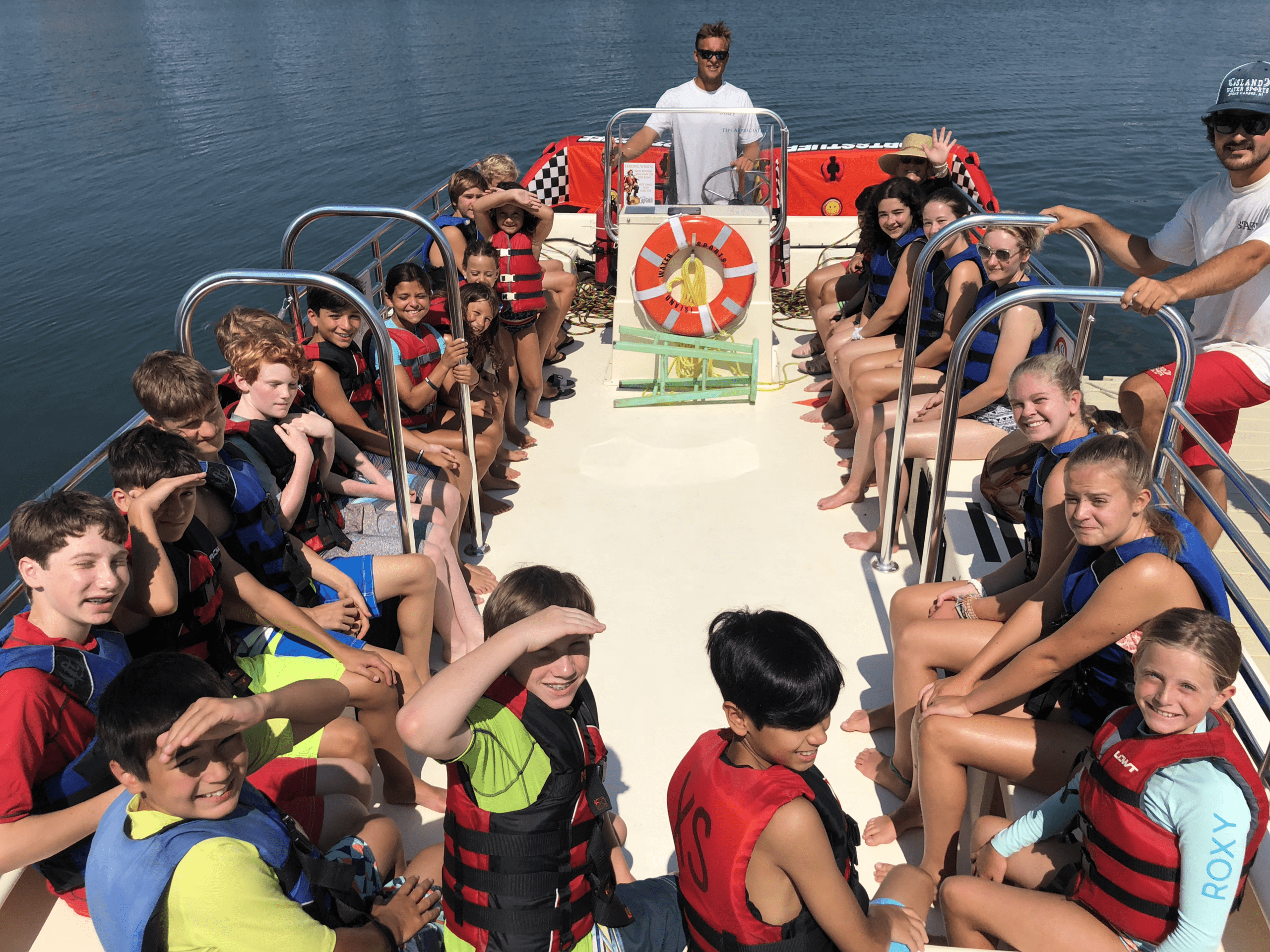 Group of kids on the Island Water Sports boat with USCG captain at the helm — birthday parties, camps, and group events welcome