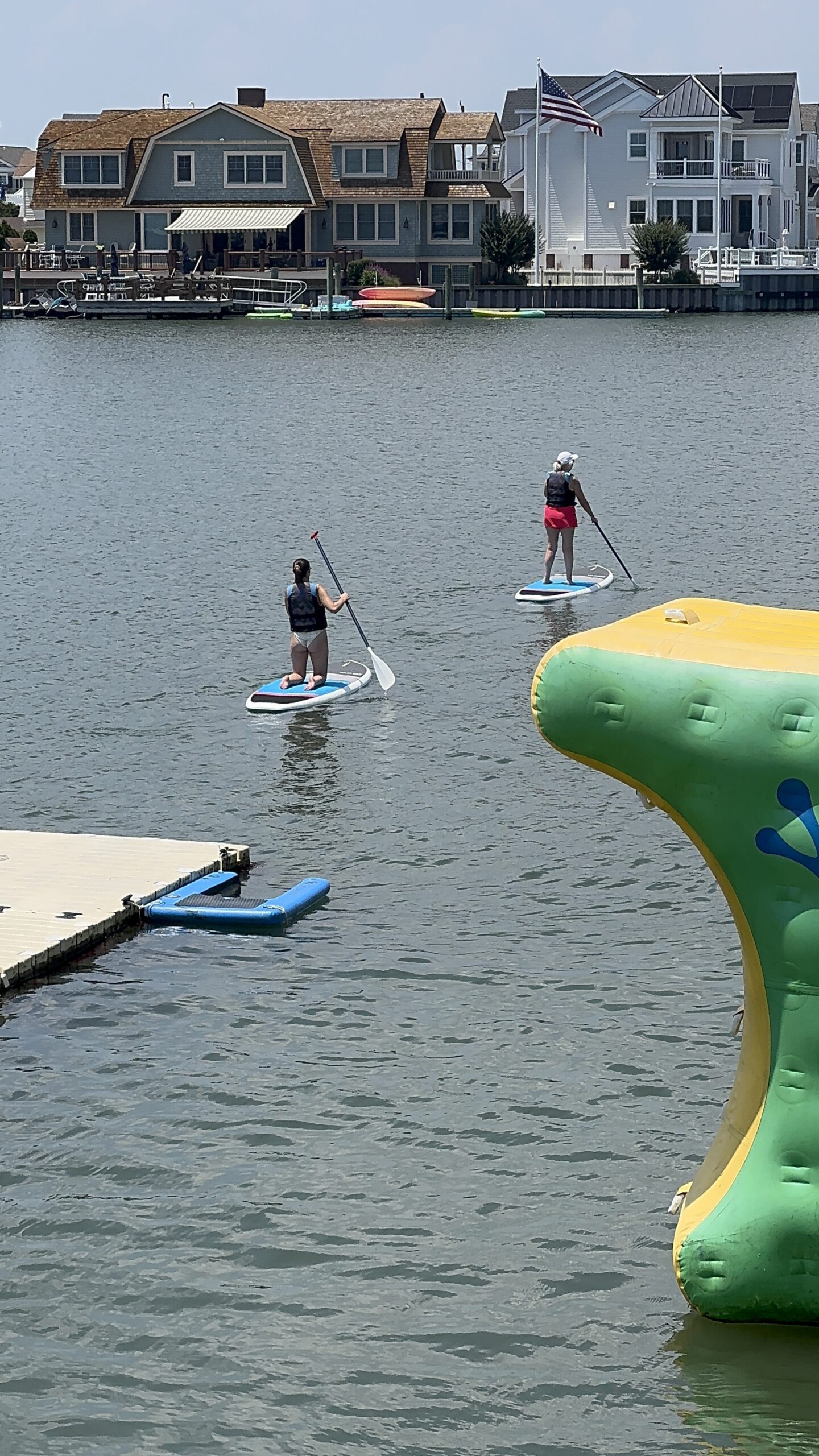 Two women paddleboarding on the Stone Harbor basin off the Island Water Sports dock