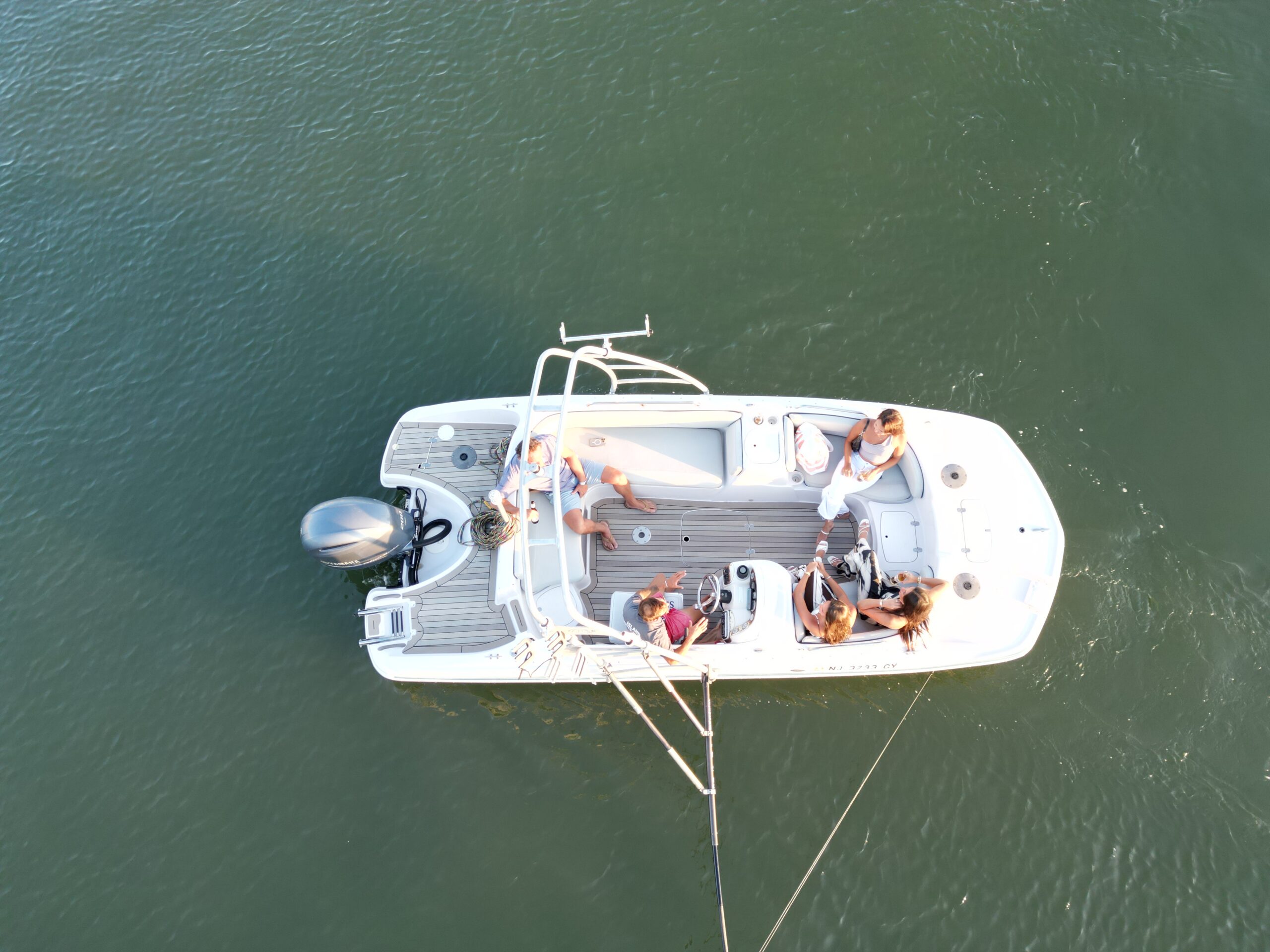 Aerial overhead view of The Basin Cruiser deck layout with teak flooring and guests aboard in Stone Harbor