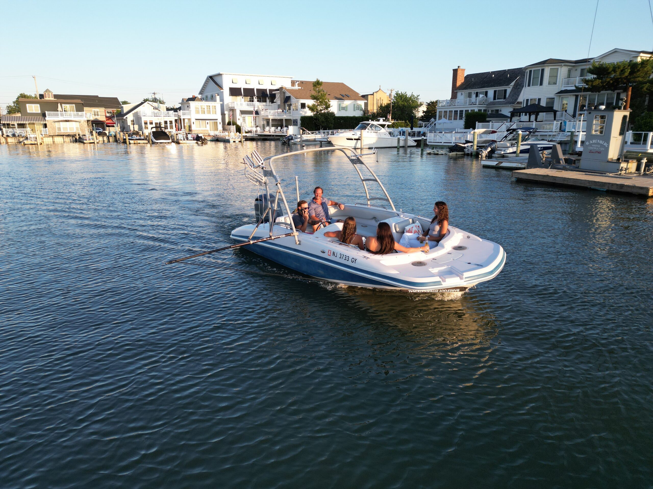 The Basin Cruiser cruising through Stone Harbor marina at sunset with guests on deck