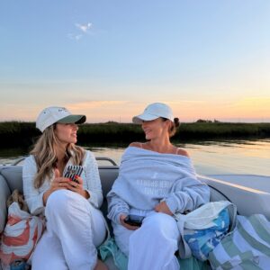 Two friends relaxing with drinks at sunset on a back bay cruise in Stone Harbor, NJ